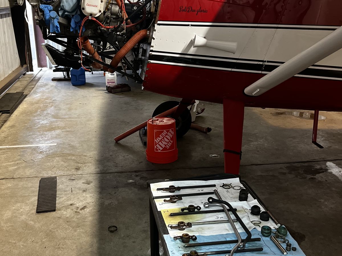 An engine opened up with its valve train parts laid out in order on a shop cart