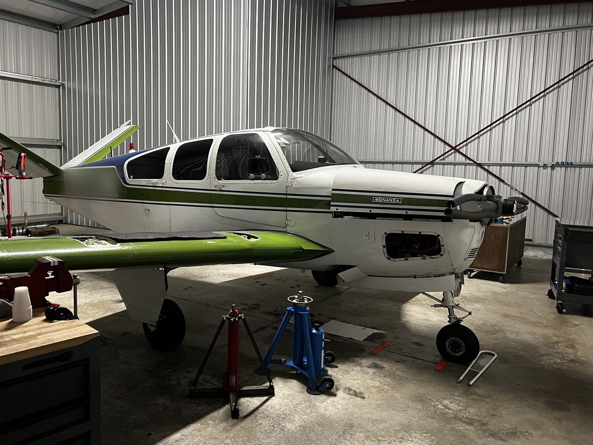 A Beechcraft Bonanza up on jacks in the hangar during maintenance
